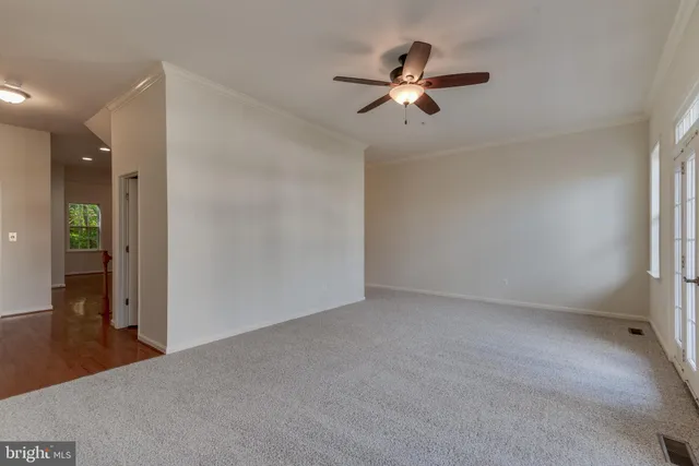a view of a livingroom with a chandelier fan and windows