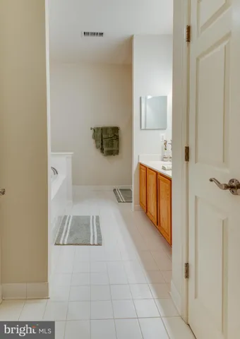a bathroom with a tub sink and mirror