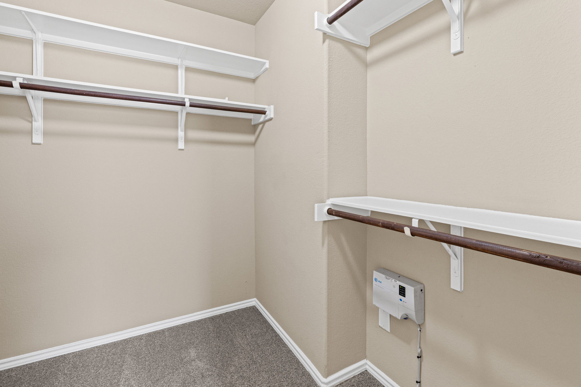 19308 Stokes Lane Pflugerville, TX 78660 - Photo 14 of 27 Walk-in closet featuring neutral carpeting, light-toned wall paint, white shelving, and hanging rods