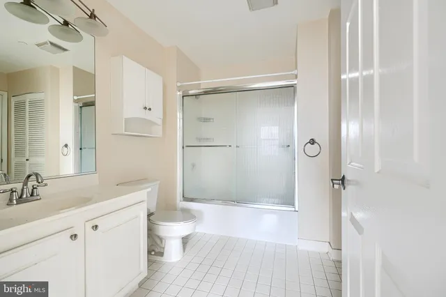 a bathroom with a shower sink vanity mirror and toilet