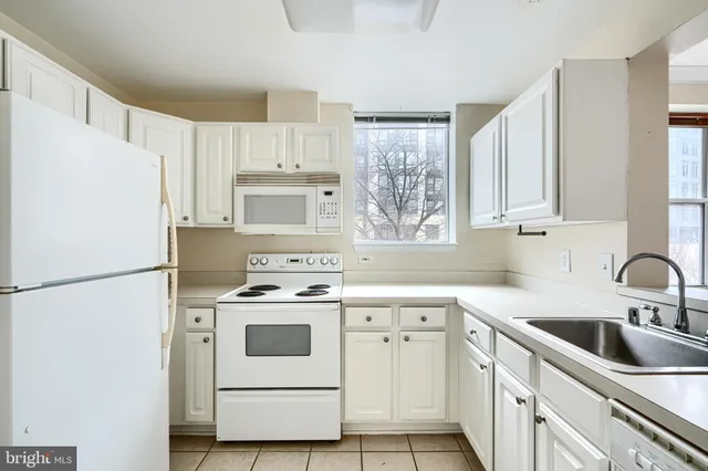 a kitchen with cabinets appliances a sink and a window