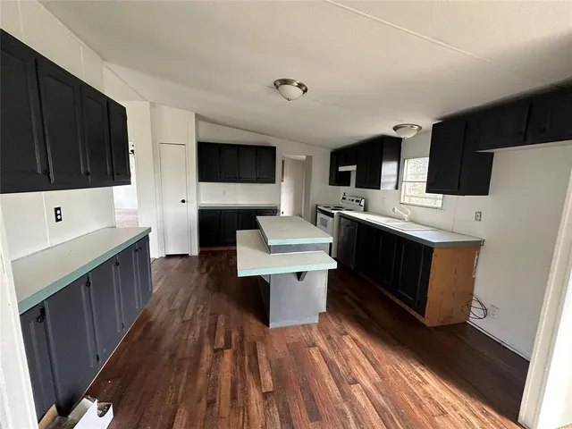 a view of a hallway to a livingroom with wooden floor and entryway