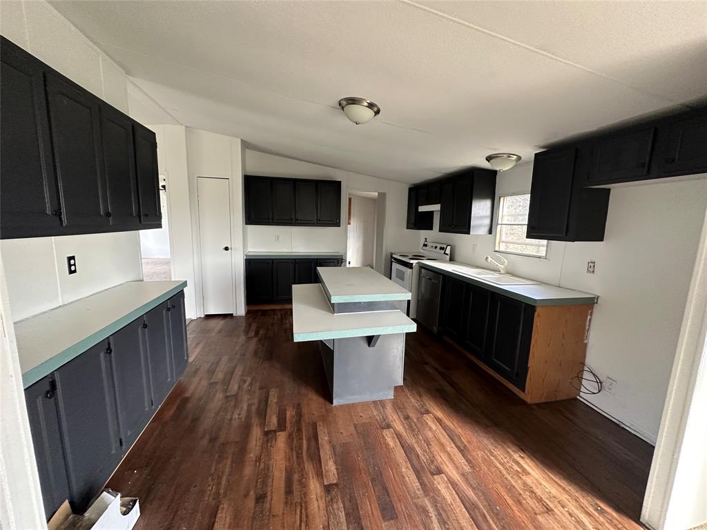 230 Largo Street Bonham, TX 75418 - Photo 20 of 34 a kitchen with a sink a microwave a refrigerator and cabinets