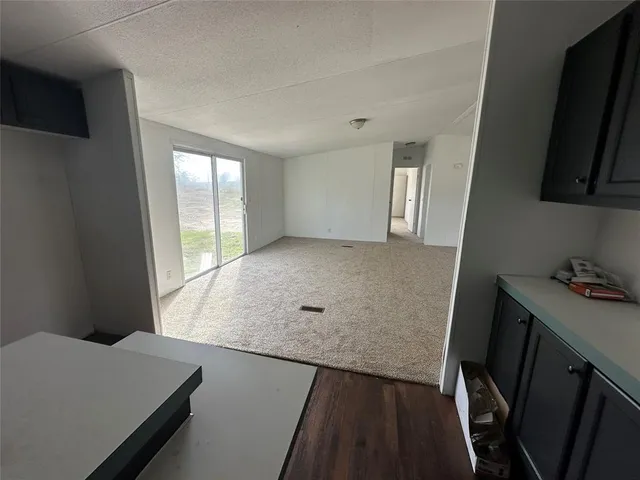 an empty room with windows and ceiling fan