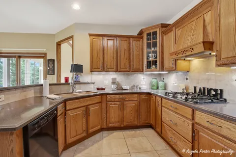 a kitchen with granite countertop a refrigerator and cabinets