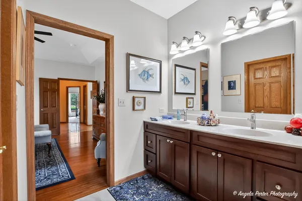 a bathroom with a toilet a sink a mirror a shower a vanity and window