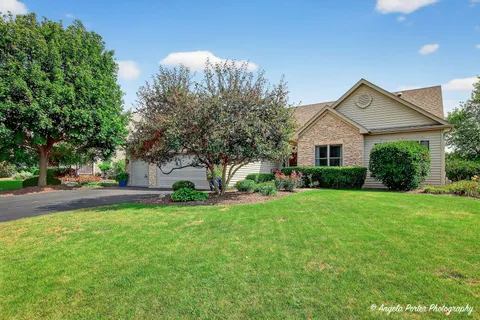 a front view of a house with a yard and trees