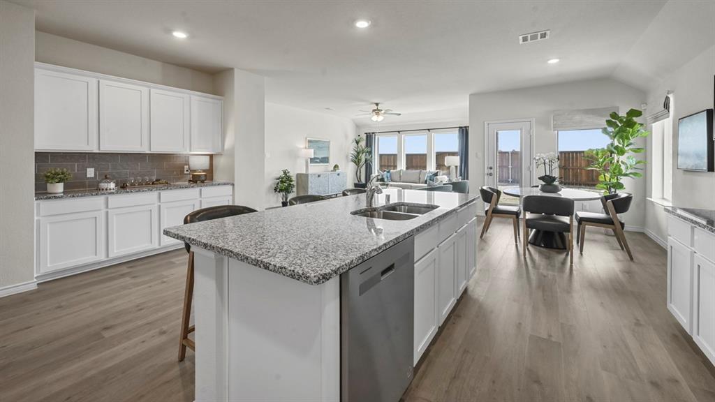 4020 Red Blf Street Pilot Point, TX 76258 - Photo 15 of 39 a kitchen with center island wooden floor and stainless steel appliances