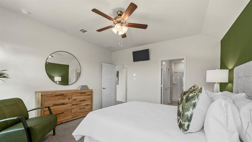 4020 Red Blf Street Pilot Point, TX 76258 - Photo 8 of 39 a bedroom with a bed a mirror on dresser and a chandelier