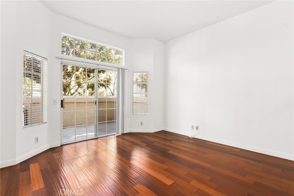 2300 Maple Avenue, Unit 26 Torrance, CA 90503 - Photo 6 of 24 an empty room with wooden floor and windows