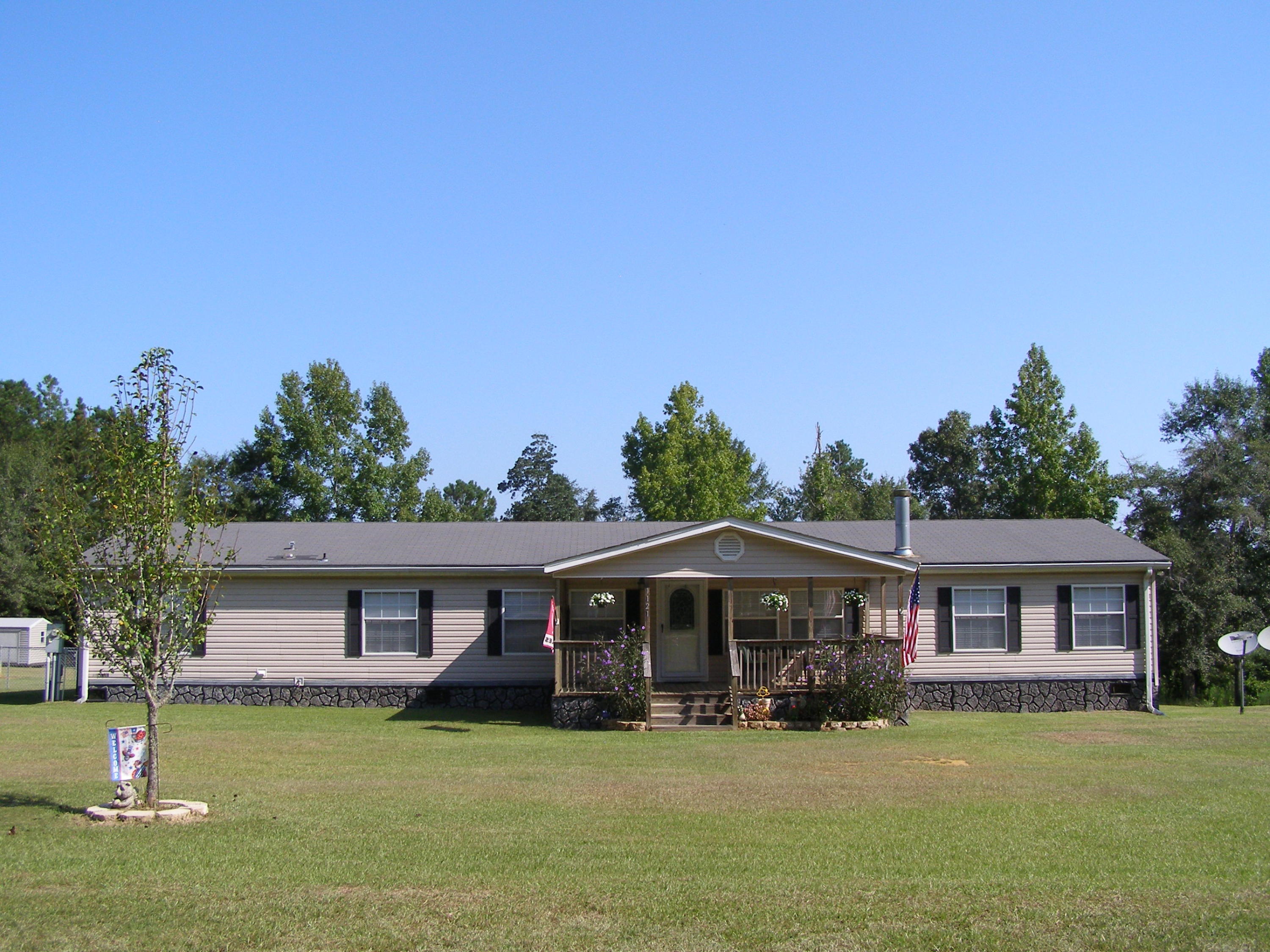 1121 State Line Road Baker, FL 32531 - Photo 1 of 25 a front view of a house with garden