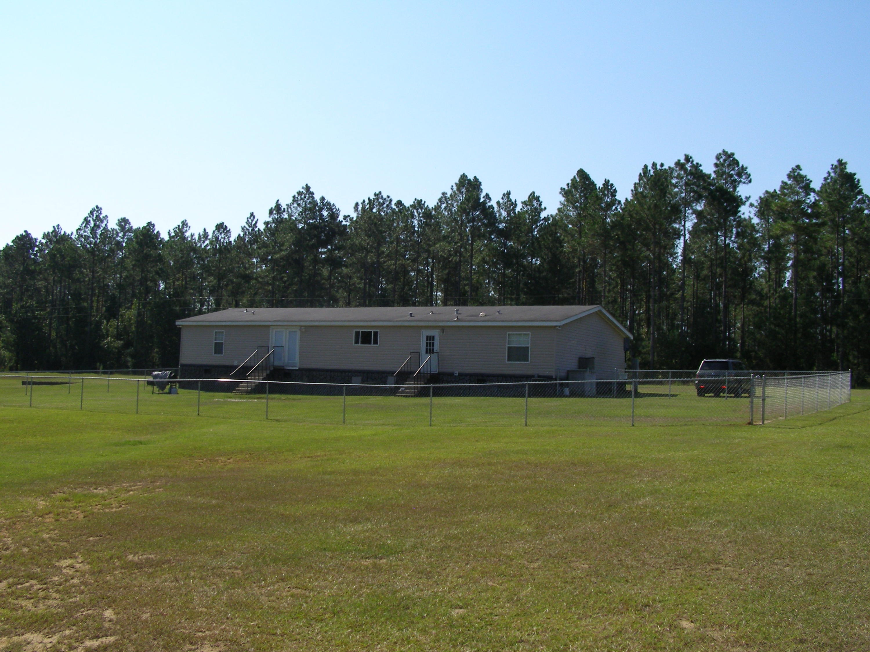 1121 State Line Road Baker, FL 32531 - Photo 6 of 25 a backyard of a house with lots of green space