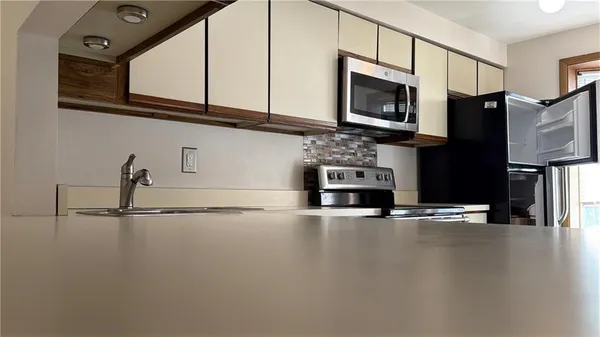 a kitchen with stainless steel appliances a stove microwave and sink