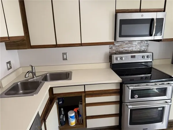 a kitchen with stainless steel appliances a stove and a microwave