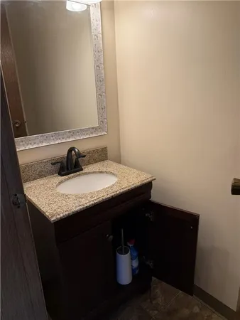 a bathroom with a granite countertop sink and a mirror