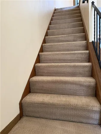 a view of staircase with lots of frames on wall