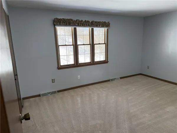 a view of a big room with wooden floor and door