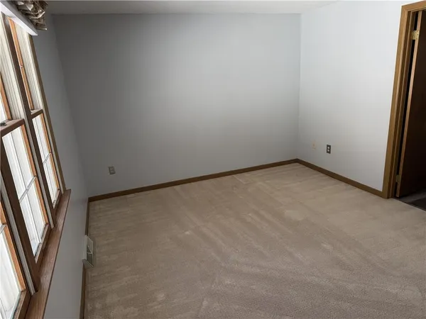 an empty room with windows and closet