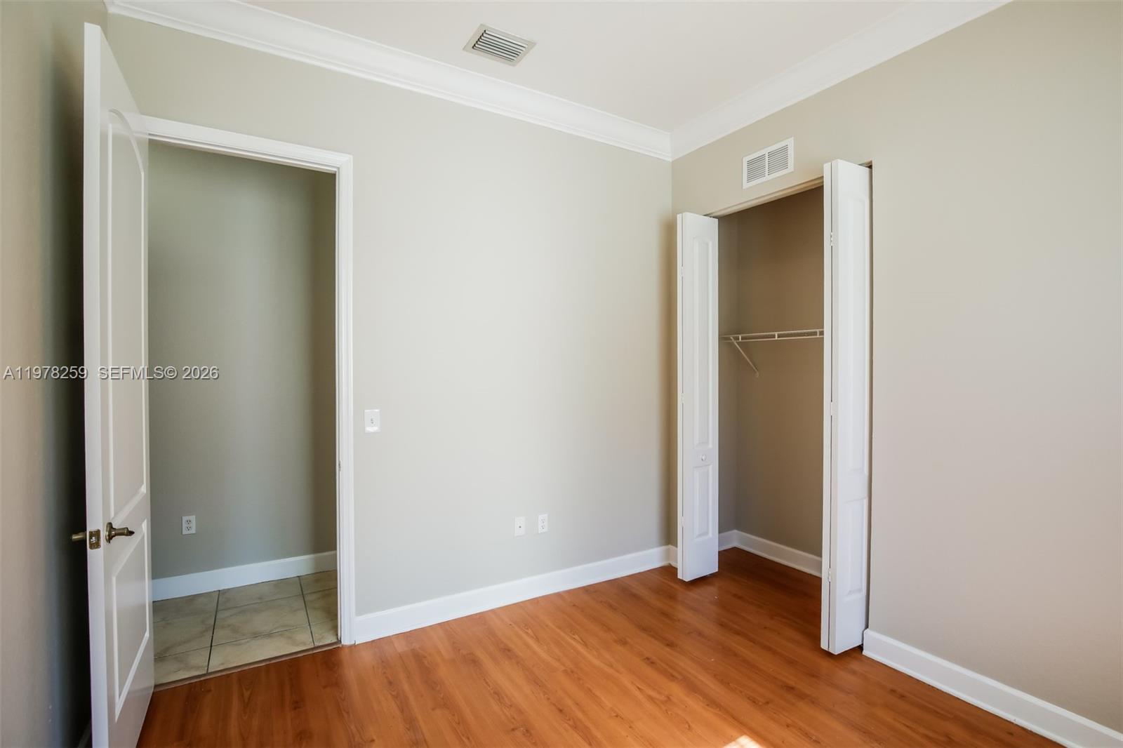 18686 Southwest 132nd Avenue Miami, FL 33177 - Photo 15 of 18 an empty room with wooden floor and closet