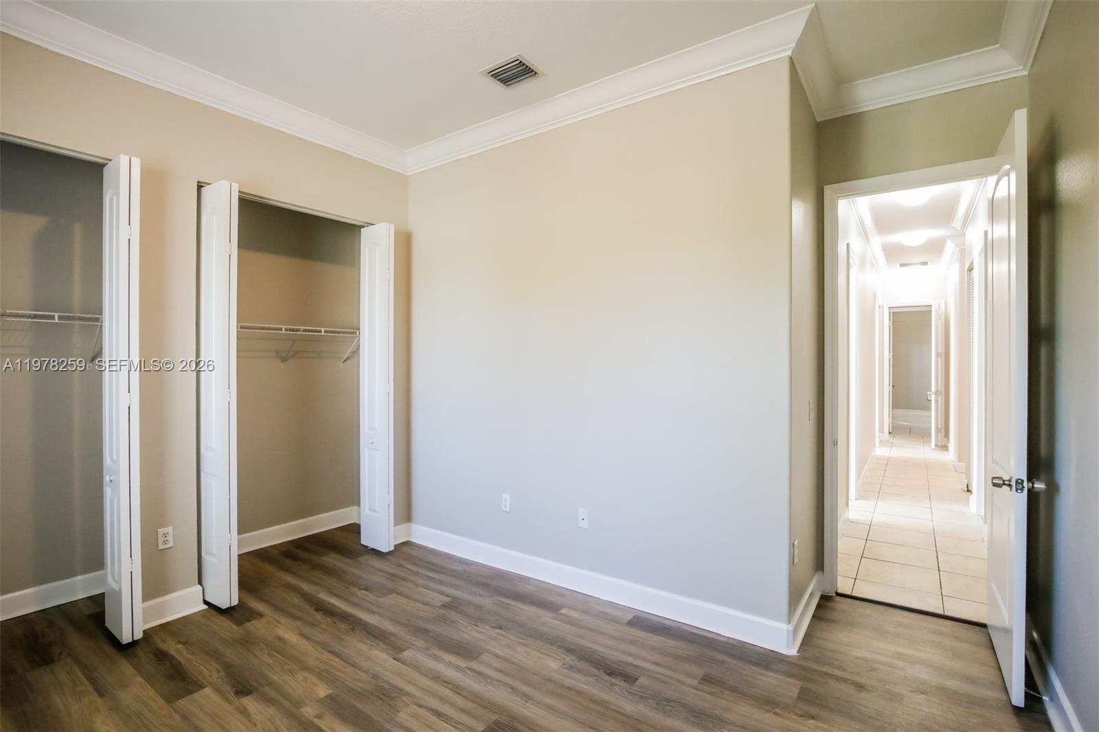 18686 Southwest 132nd Avenue Miami, FL 33177 - Photo 16 of 18 an empty room with wooden floor & closet area