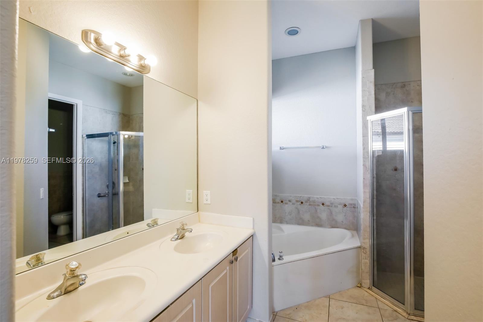 18686 Southwest 132nd Avenue Miami, FL 33177 - Photo 17 of 18 a bathroom with a granite countertop sink a toilet and shower