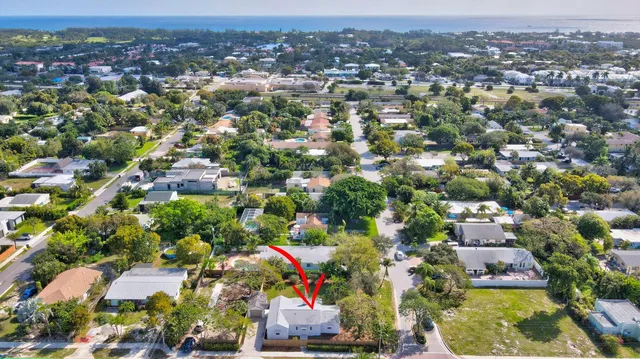 an aerial view of residential houses with outdoor space and trees