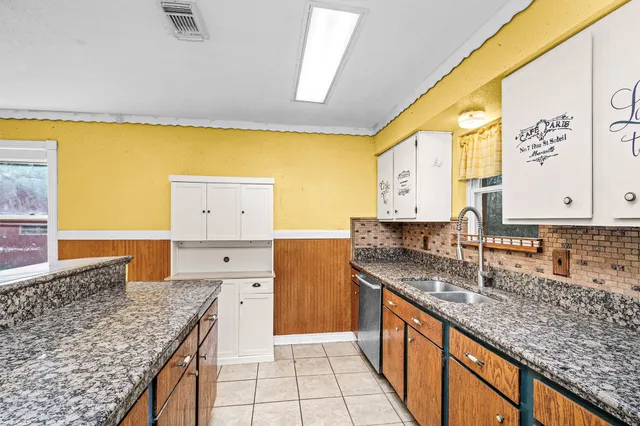 a kitchen with stainless steel appliances granite countertop a sink and a stove
