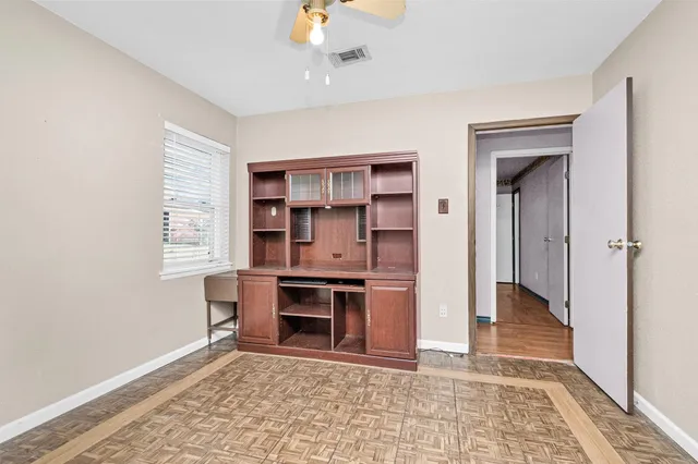 a view of an empty room with window and cabinet