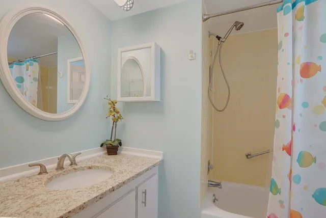 a bathroom with a granite countertop sink and a mirror
