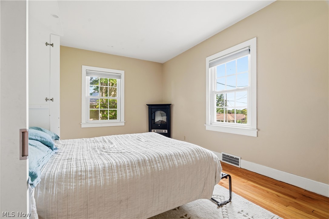 1769 Paradise Road Orrville, OH 44667 - Photo 14 of 36 Bedroom featuring wood-finish flooring, two large windows with white trim, and light-toned walls