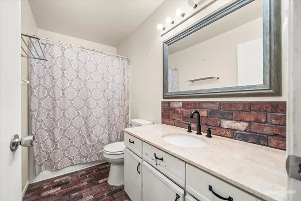 a bathroom with a granite countertop sink a toilet and a mirror