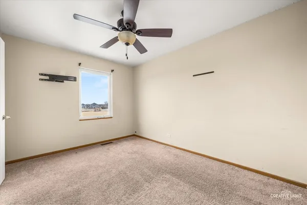 an empty room with a window and a fan
