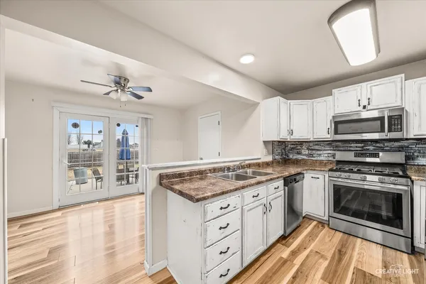 a kitchen with stainless steel appliances granite countertop a stove sink and cabinets