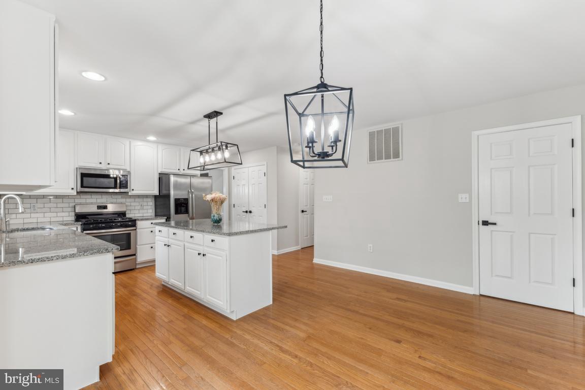 5 Basalt Drive Fredericksburg, VA 22406 - Photo 17 of 41 a kitchen with stainless steel appliances granite countertop a refrigerator a stove oven a sink dishwasher and white cabinets with wooden floor