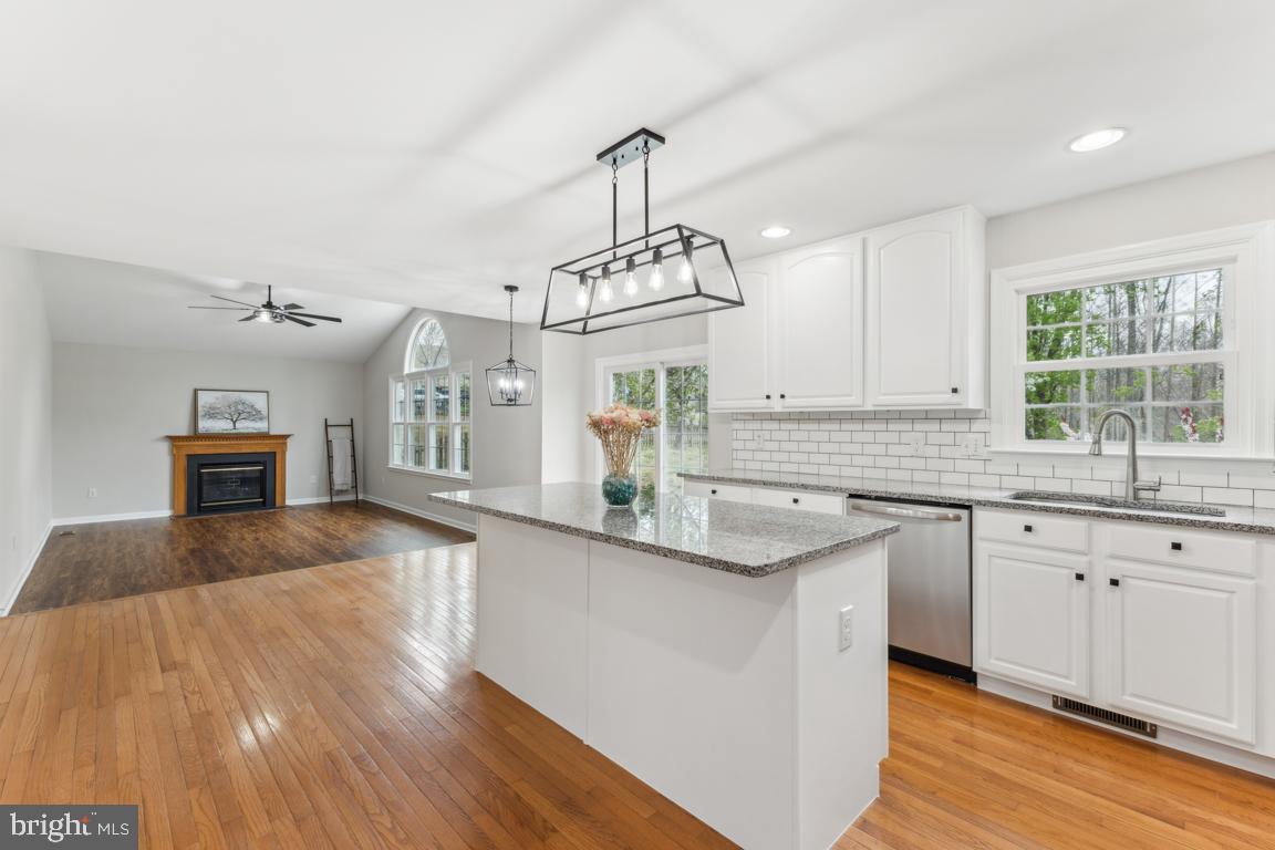 5 Basalt Drive Fredericksburg, VA 22406 - Photo 20 of 41 a kitchen with kitchen island granite countertop a sink dishwasher a stove a dining table and chairs with wooden floor