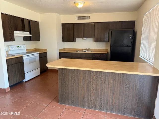 a kitchen with stainless steel appliances a refrigerator and a stove top oven