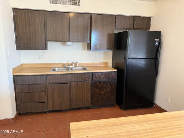 a kitchen with stainless steel appliances granite countertop a refrigerator and a sink