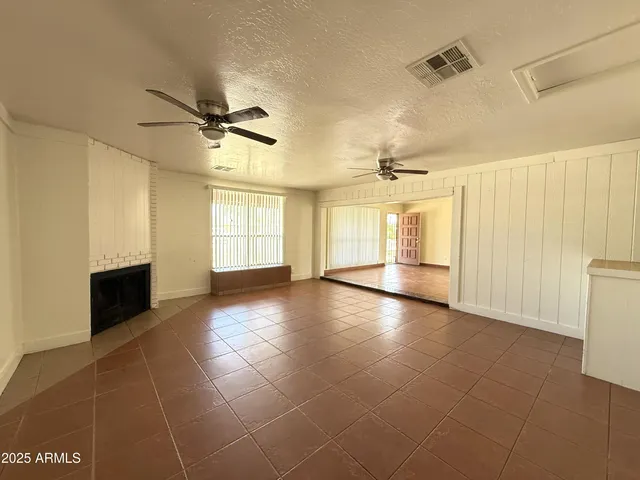 a view of an empty room with a fireplace and a window
