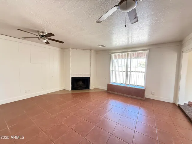 a view of an empty room with a fireplace and a window