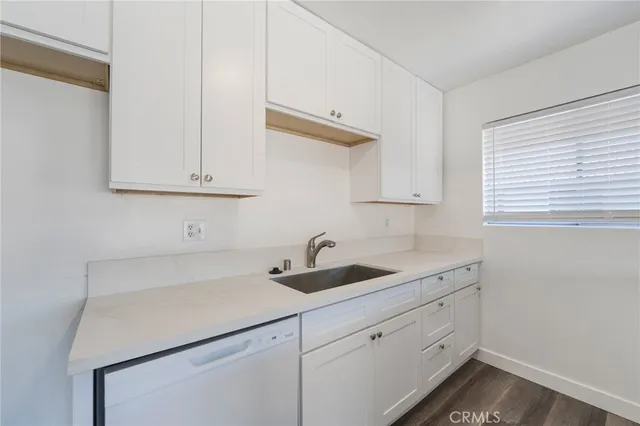 a kitchen with white cabinets and a sink