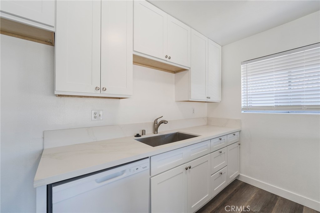 2155 Canyon Drive, Unit D Costa Mesa, CA 92627 - Photo 11 of 27 a kitchen with white cabinets and a sink