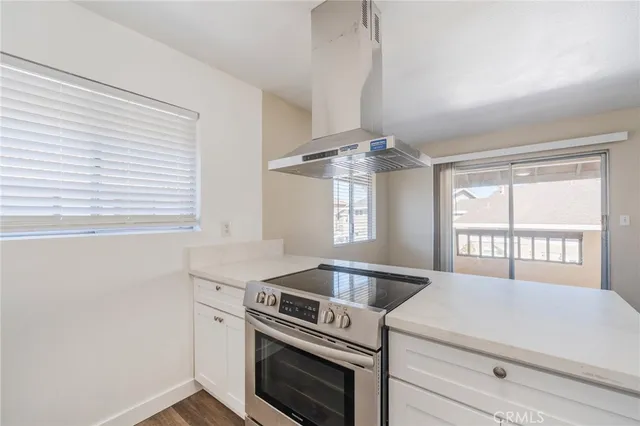 a kitchen with a stove and a wooden floor