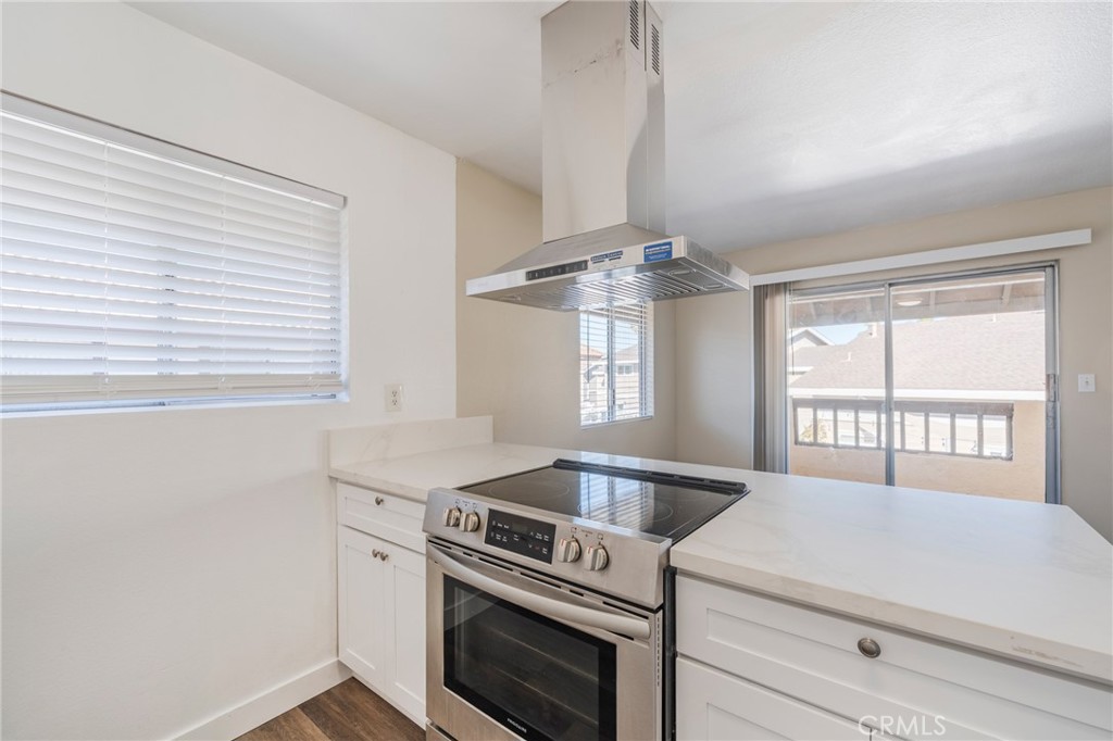 2155 Canyon Drive, Unit D Costa Mesa, CA 92627 - Photo 12 of 27 a kitchen with a stove and a wooden floor