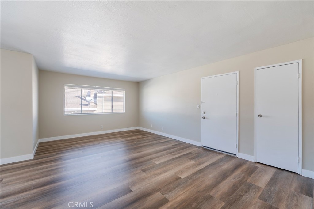 2155 Canyon Drive, Unit D Costa Mesa, CA 92627 - Photo 7 of 27 an empty room with wooden floor and windows