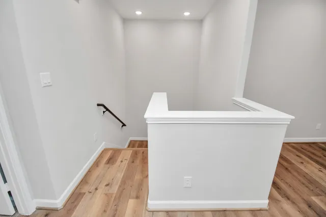 a view of a hallway with wooden floor