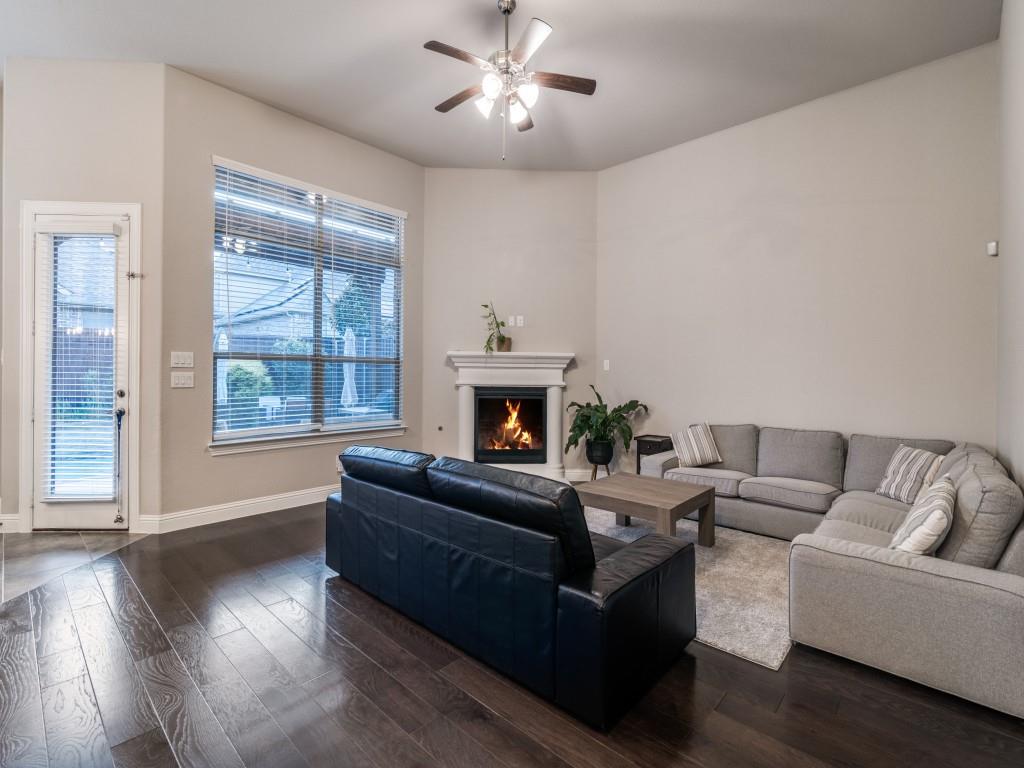 3323 Royal Ridge Drive Rockwall, TX 75087 - Photo 10 of 40 Living area featuring dark wood finished floors, a ceiling fan, and a warm lit electronic gas log fireplace