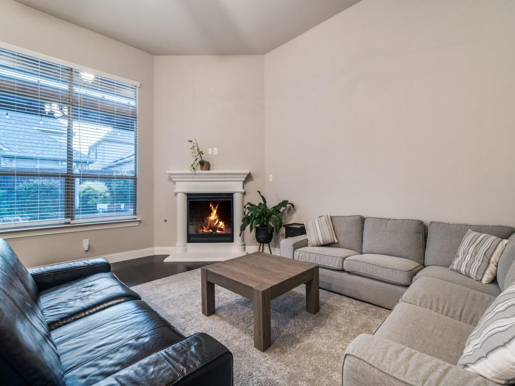 3323 Royal Ridge Drive Rockwall, TX 75087 - Photo 11 of 40 Living area with a lit electronic gas log fireplace and wood finished floors