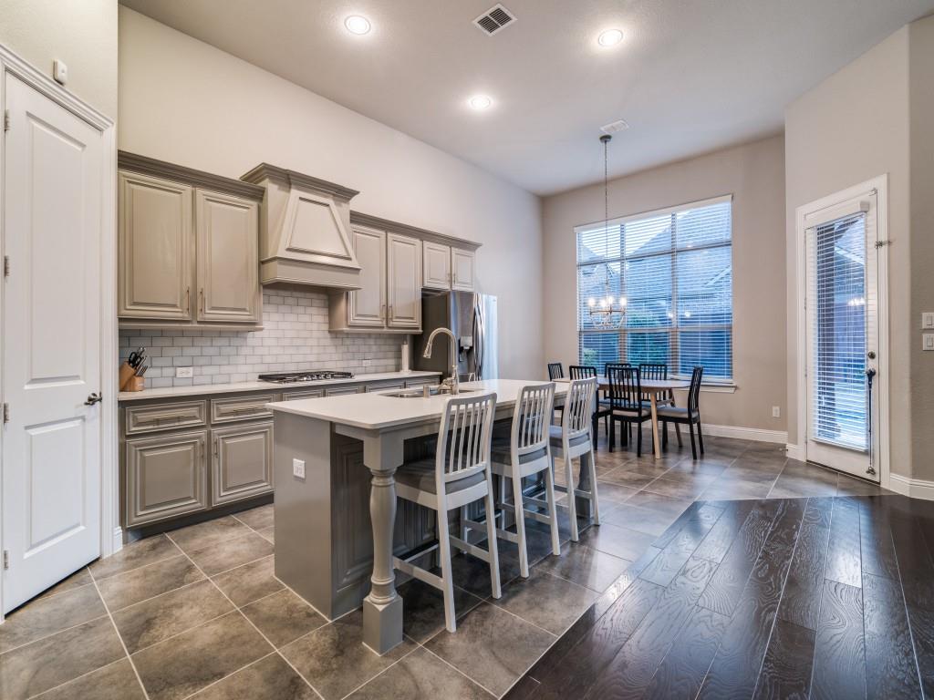 3323 Royal Ridge Drive Rockwall, TX 75087 - Photo 12 of 40 Kitchen featuring custom exhaust hood, appliances with stainless steel finishes, a chandelier, a center island with sink, and light countertops