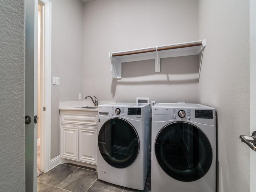 3323 Royal Ridge Drive Rockwall, TX 75087 - Photo 33 of 40 First floor Laundry area featuring washing machine and dryer, cabinet space, and dark tile patterned flooring as you enter from the single car garage.