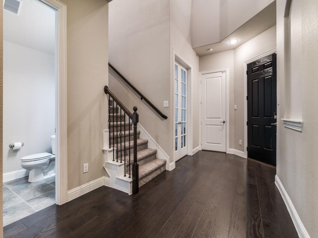 3323 Royal Ridge Drive Rockwall, TX 75087 - Photo 6 of 40 Foyer entrance featuring dark wood-style floors and stairway. Features a half bath on first level.